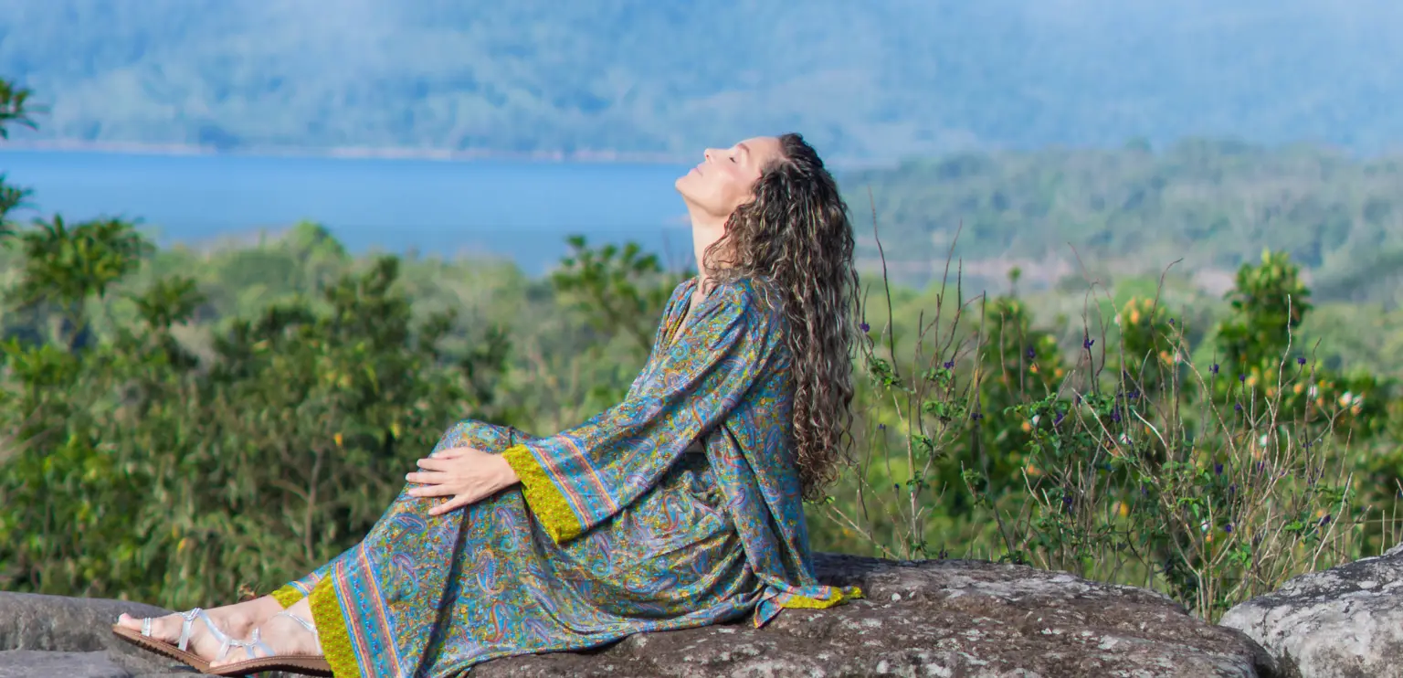 Woman in peaceful meditation pose enjoying nature and lake views during a wellness retreat in Costa Rica