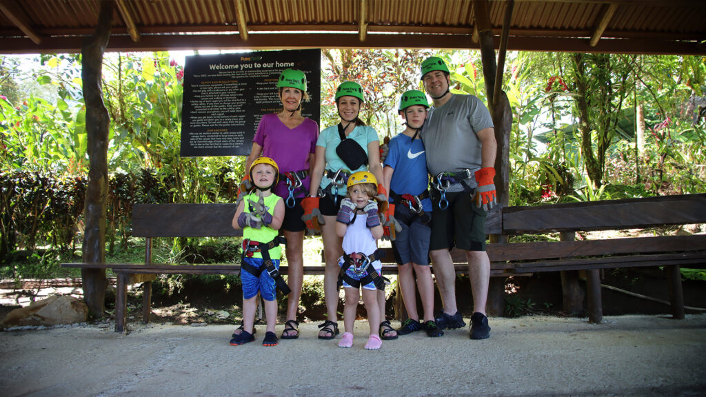 Family preparing for a guided canyoning adventure with Pure Trek in La Fortuna, Costa Rica, wearing helmets and safety gear.