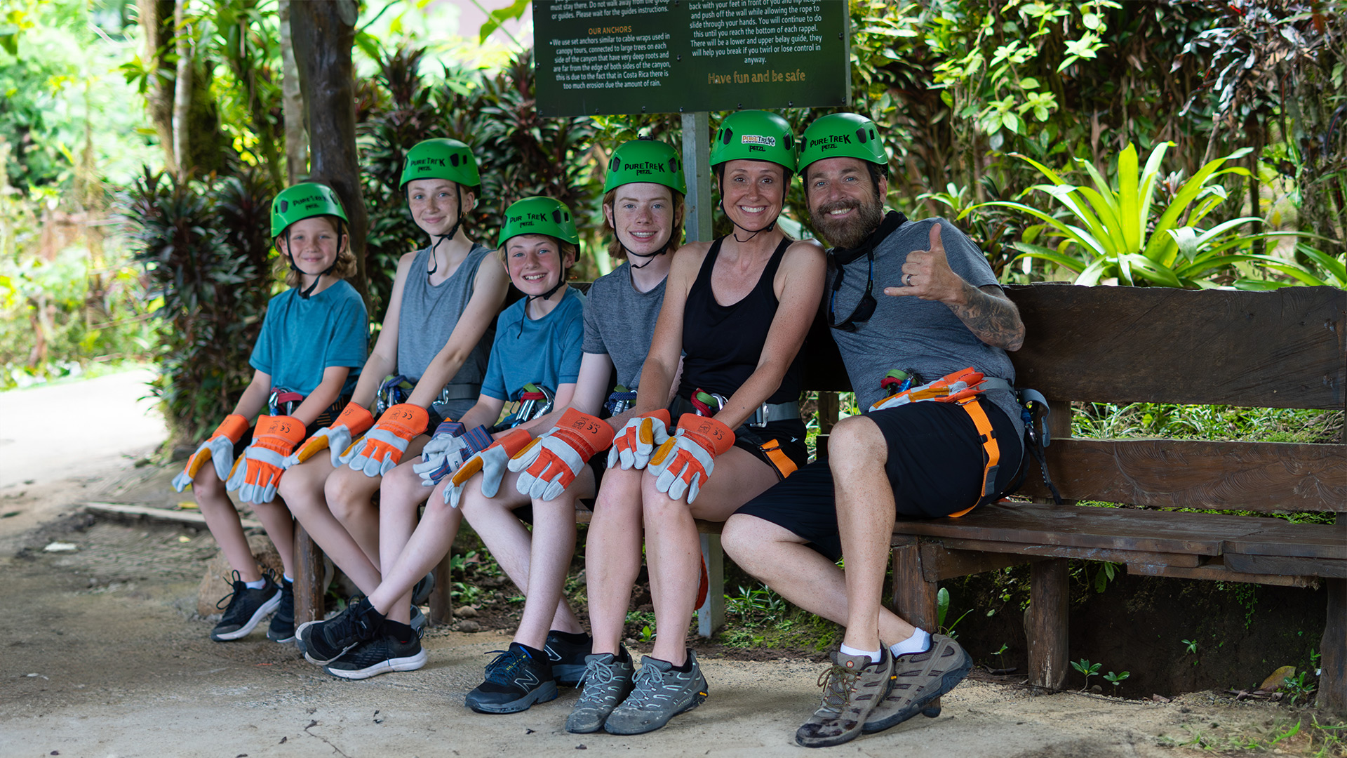 Family ready for a guided canyoning adventure with Pure Trek in La Fortuna, Costa Rica, wearing safety gear and helmets.