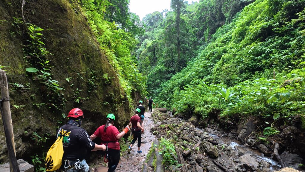 Guided canyoning group hiking through a rainforest canyon during a Pure Trek tour in La Fortuna, Costa Rica.