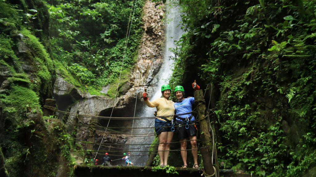 Two women celebrating after a waterfall canyoning experience with Pure Trek in La Fortuna, Costa Rica.