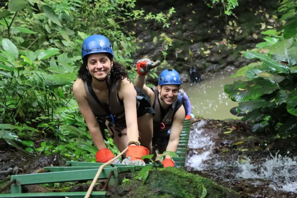Guests climbing through the rainforest during a canyoning adventure at Rainforest Falls in Arenal, Costa Rica.